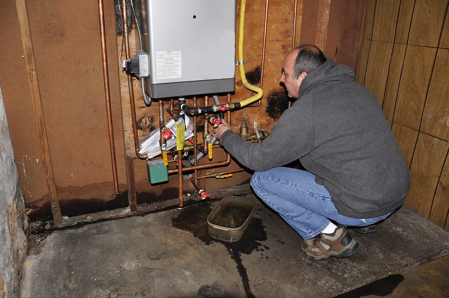 Fixing a leaking indoor HVAC unit.
